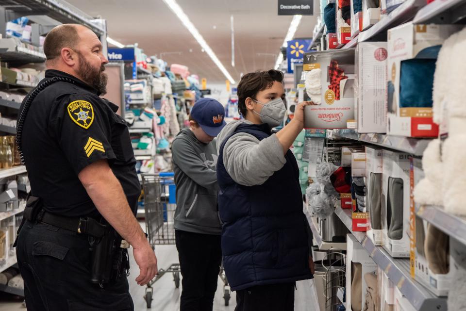 Sgt. Dan Boyle, from the Bucks County Sheriff's Office, helps Edwin Rosa, 14, of Doylestown, pick out a blanket during Plumstead Township Police Department's 5th annual Shop with a Cop event at Walmart in Hilltown Township on Tuesday, Dec. 8, 2021. Funded by community donations, the program paired law enforcement officers from 11 local departments with more than 100 kids to help them shop for presents for themselves and their families.