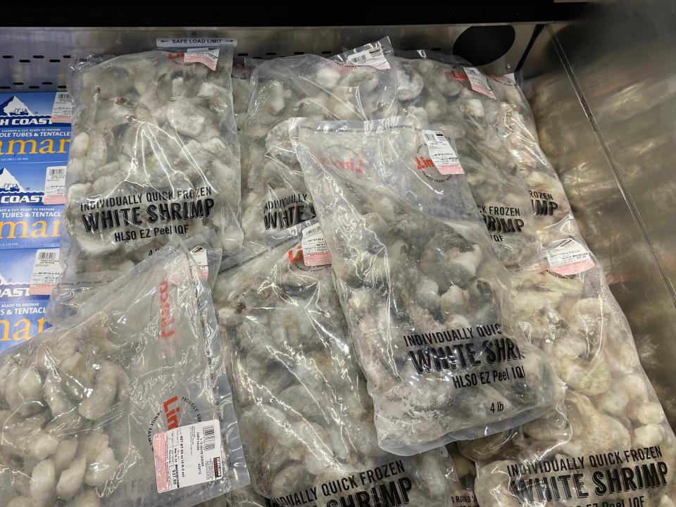 Clear bags of frozen white shrimp in refrigerated section at Costco