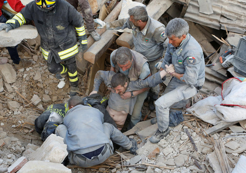 <p>A man is rescued alive from the ruins following an earthquake in Amatrice, central Italy on Aug. 24, 2016. (REUTERS/Remo Casilli) </p>