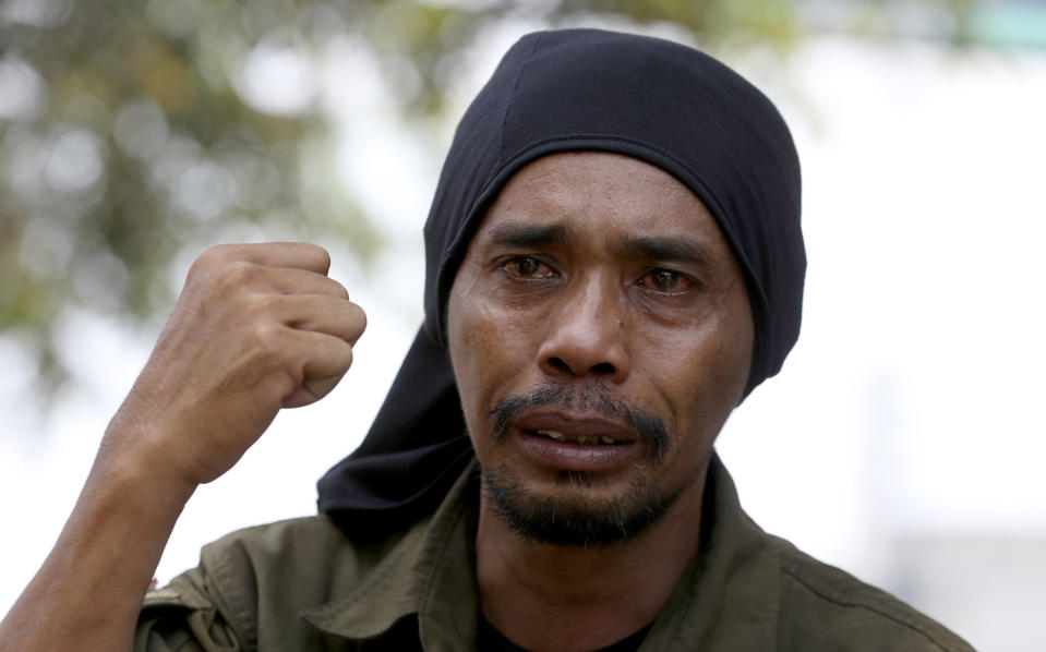 Medi Bastoni, 43, gestures as he talk to journalist in Bekasi, outskirt of Jakarta, Indonesia, Thursday, Aug, 22, 2019. The Indonesian man is walking over 700-kilometer (430-mile) backward from his home in eastern Java to the country's capital to draw awareness of deforestation.(AP Photo/Achmad Ibrahim)