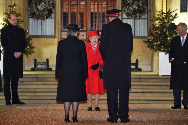 Britain's Queen Elizabeth II stands with Britain's Prince William, Duke of Cambridge, (L) and Britain's Prince Charles, Prince of Wales (R) as they thank local volunteers and key workers for the work they are doing during the coronavirus pandemic and over Christmas in the quadrangle of Windsor Castle in Windsor, west of London, on December 8, 2020 - The Queen and members of the royal family gave thanks to local volunteers and key workers for their work in helping others during the coronavirus pandemic and over Christmas at Windsor Castle in what was also the final stop for the Duke and Duchess of Cambridge on their tour of England, Wales and Scotland. (Photo by Glyn KIRK / various sources / AFP) (Photo by GLYN KIRK/AFP via Getty Images)