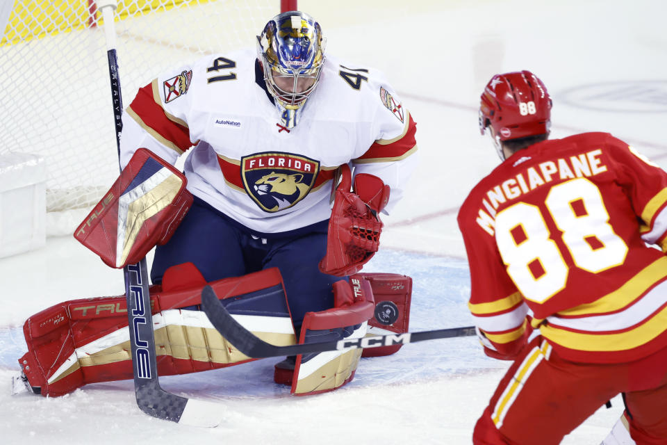 Florida Panthers goalie Anthony Stolarz, left, stops a shot by Calgary Flames winger Andrew Mangiapane during the first period of an NHL hockey game in Calgary, Alberta., Monday, Dec. 18, 2023. (Larry MacDougal/The Canadian Press via AP)