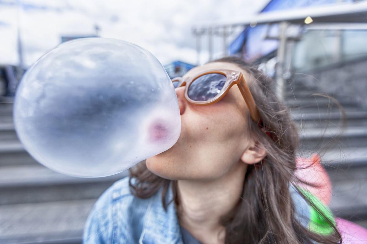 Woman portrait blowing a bubble chewing gum