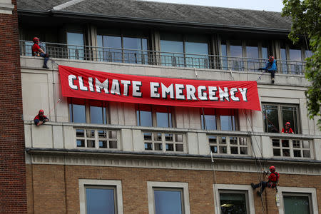 Greenpeace activists hang from ropes as they unfurl a banner on the BP headquarters in London, Britain May 20, 2019. REUTERS/Simon Dawson