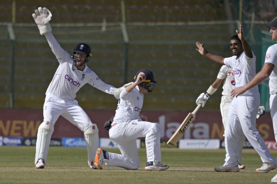 England's Rehan Ahmed, right, and Ben Foakes, left, react after teammate Ollie Pope taking the catch of Pakistan's Saud Shakeel during the first day of third test cricket match between England and Pakistan, in Karachi, Pakistan, Saturday, Dec. 17, 2022. (AP Photo/Fareed Khan)