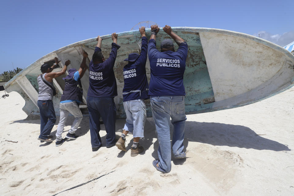 Empleados estatales reubican un bote para protegerlo antes de la llegada del huracán Beryl el jueves 4 de julio de 2024, en Progreso, México. (AP Foto/Martín Zetina)