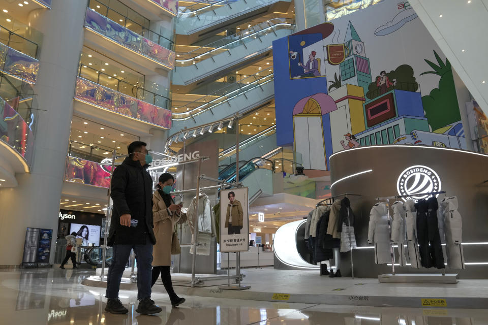 Shoppers walk through a reopened shopping mall after authorities started easing some of the anti-virus controls in Beijing, Tuesday, Dec. 6, 2022. China is the only major country still trying to stamp out transmission while the United States and others relax restrictions and try to live with the virus that has killed and infected millions of people. (AP Photo/Andy Wong)