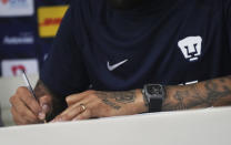 Brazilian Dani Alves signs a contract during a press conference where he was presented as a new member of the Pumas UNAM soccer club, in Mexico City, Saturday, July 23, 2022. (AP Photo/Marco Ugarte)
