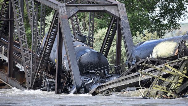 PHOTO: Several train cars are immersed in the Yellowstone River after a bridge collapse near Columbus, Mont., on June 24, 2023. (Matthew Brown/AP)