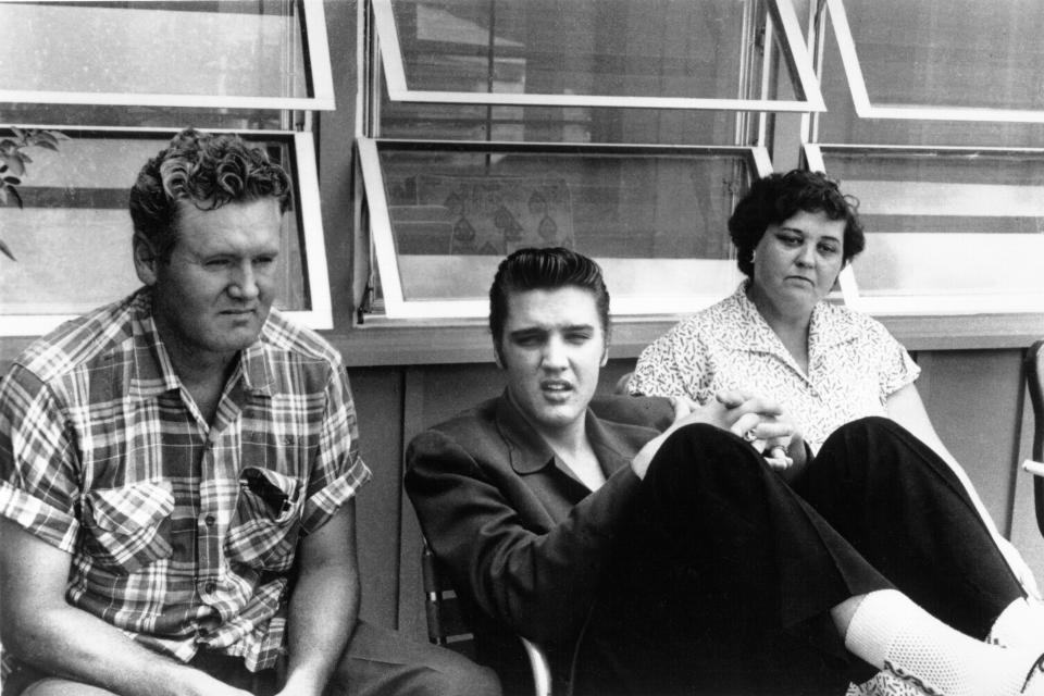 1956:  Rock and roll singer Elvis Presley relaxes with his parents Vernon and Gladys in 1956. (Photo by Michael Ochs Archives/Getty Images)
