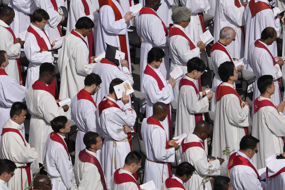 Clerics attend the Palm Sunday's mass celebrated by Pope Francis in St. Peter's Square at The Vatican Sunday, April 2, 2023 a day after being discharged from the Agostino Gemelli University Hospital in Rome, where he has been treated for bronchitis, The Vatican said. The Roman Catholic Church enters Holy Week, retracing the story of the crucifixion of Jesus and his resurrection three days later on Easter Sunday. (AP Photo/Andrew Medichini)