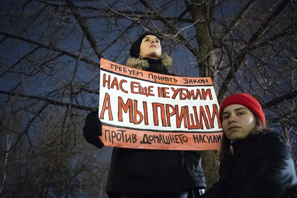 FILE - In this Nov. 25, 2019, file photo, a woman holds a banner reading, "We demand the adoption of a law against domestic violence. We have not been killed yet, but we're close," as she attends a rally in Moscow, Russia. Few reliable official statistics are kept on violence against women in Russia, but it is clearly a national problem. Police routinely turn a blind eye to domestic abuse, and restraining orders don't exist, leaving victims without a key protection. (AP Photo/Pavel Golovkin, File)