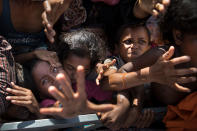 <p>Desperate Rohingya grab for aid handouts of clothing and food on September 15, 2017, in Tankhali, Bangladesh. (Photograph by Paula Bronstein/Getty Images) </p>