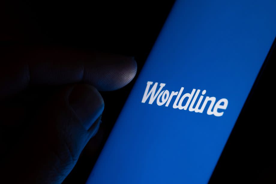 tone / United Kingdom - February 4 2020: Worldline payment company logo on the blue screen and finger about to touch it. Concept photo.