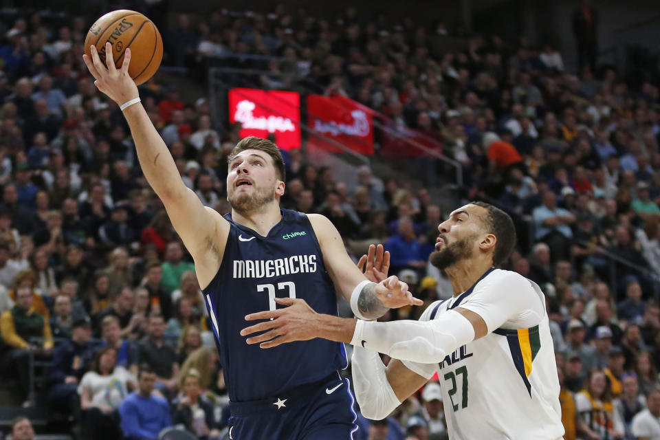 Dallas Mavericks guard Luka Doncic (77) lays the ball up as Utah Jazz center Rudy Gobert (27) defends in the first half during an NBA basketball game Saturday, Jan. 25, 2020, in Salt Lake City. (AP Photo/Rick Bowmer)