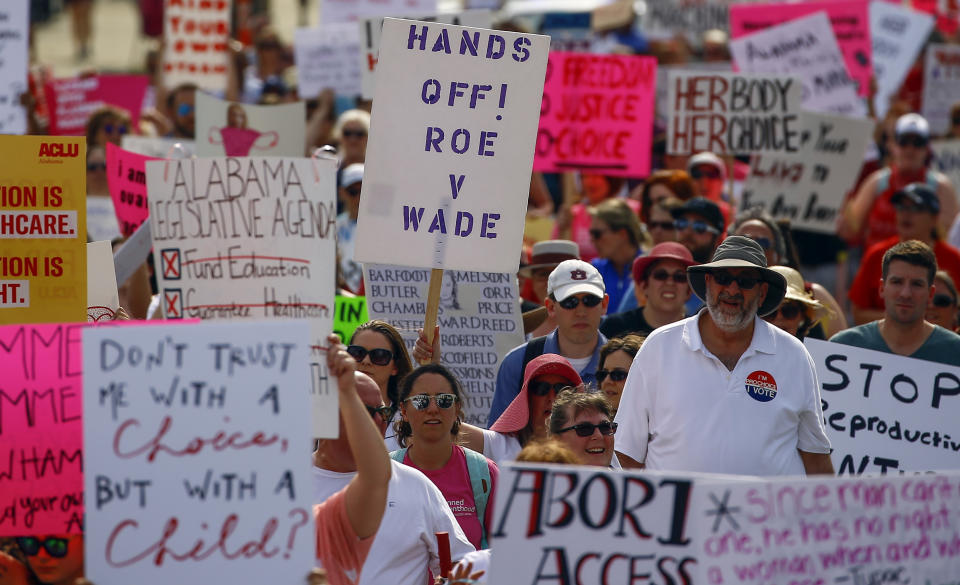 Protesters for women's rights march to the Alabama Capitol to protest a law passed last week making abortion a felony in nearly all cases with no exceptions for cases of rape or incest, Sunday, May 19, 2019, in Montgomery, Ala. (AP Photo/Butch Dill)