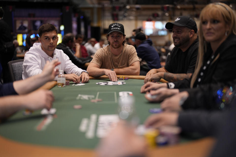 Vegas Golden Knights right wing Jonathan Marchessault, center, plays poker during the $5,000 Champions Reunion No-Limit Hold'em Freezeout event at the World Series of Poker, Tuesday, May 28, 2024, in Las Vegas. (AP Photo/John Locher)