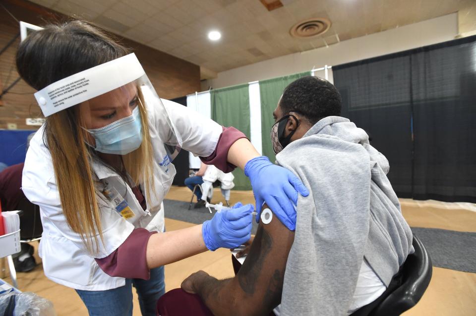 Walmart pharmacist Joni Nicastro gives a COVID-19 vaccine to Dupree Younger of Erie on in this March 2021 file photo taken at the Booker T. Washington Center. Distribution of the new COVID-19 vaccine has not gone as smoothly as planned.