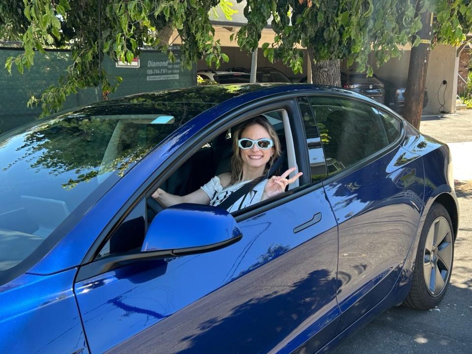 A woman driving a Tesla Model 3