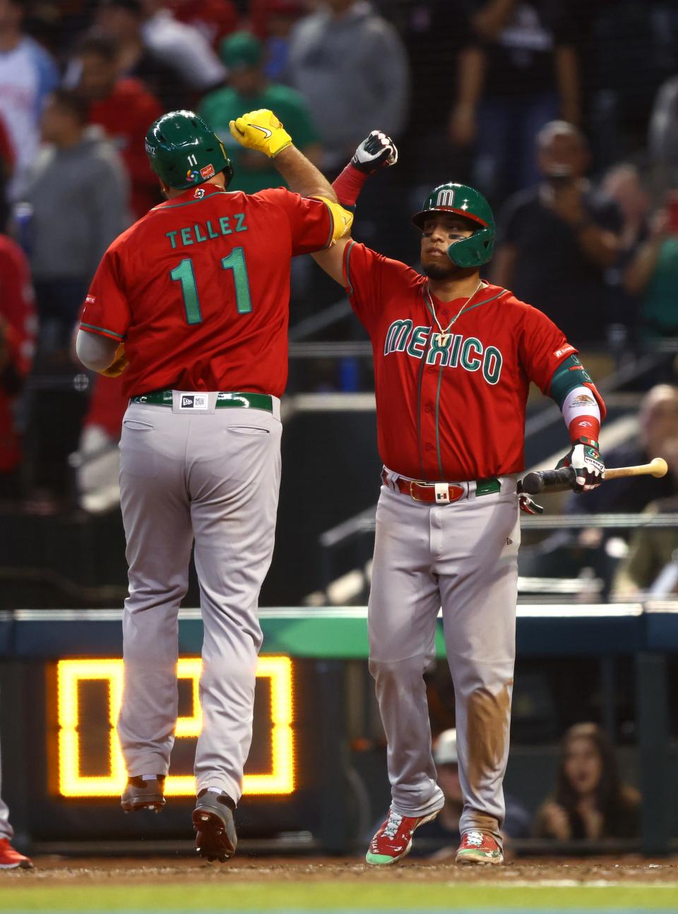 Mexico designated hitter Rowdy Tellez (11) celebrates with teammates Isaac Paredes after hitting a solo home run in the eighth inning against Canada during the World Baseball Classic at Chase Field in Phoenix on March 15, 2023.