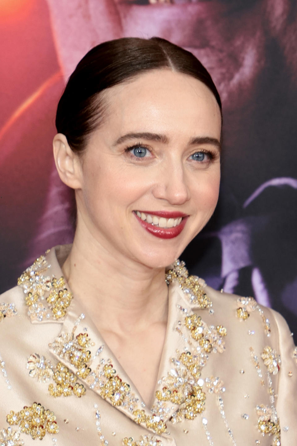 Close-up of Zoe smiling in a shiny, satiny top and hair pulled back