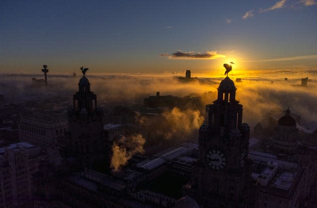 The sun rises behind The Royal Liver Building in Liverpool, Merseyside