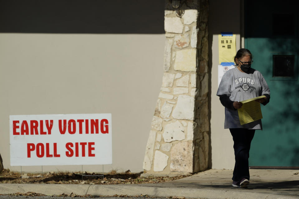 A woman exits an early voting poll site, Monday, Feb. 14, 2022, in San Antonio. Early voting in Texas began Monday. (AP Photo/Eric Gay)