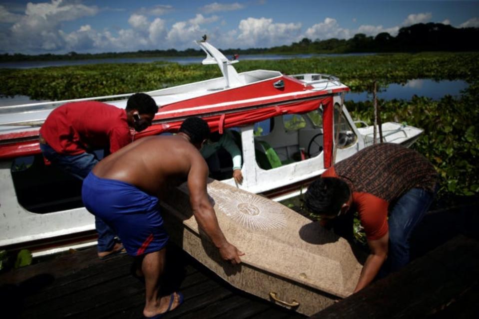 Familiares de Andrelina Bizerra da Silva, de 49 años, que murió mientras era trasladada en barco a una clínica, suben su ataúd a un bote para llevar su cuerpo de vuelta al municipio de Breves. (Foto: Uesley Marcelino / Reuters).