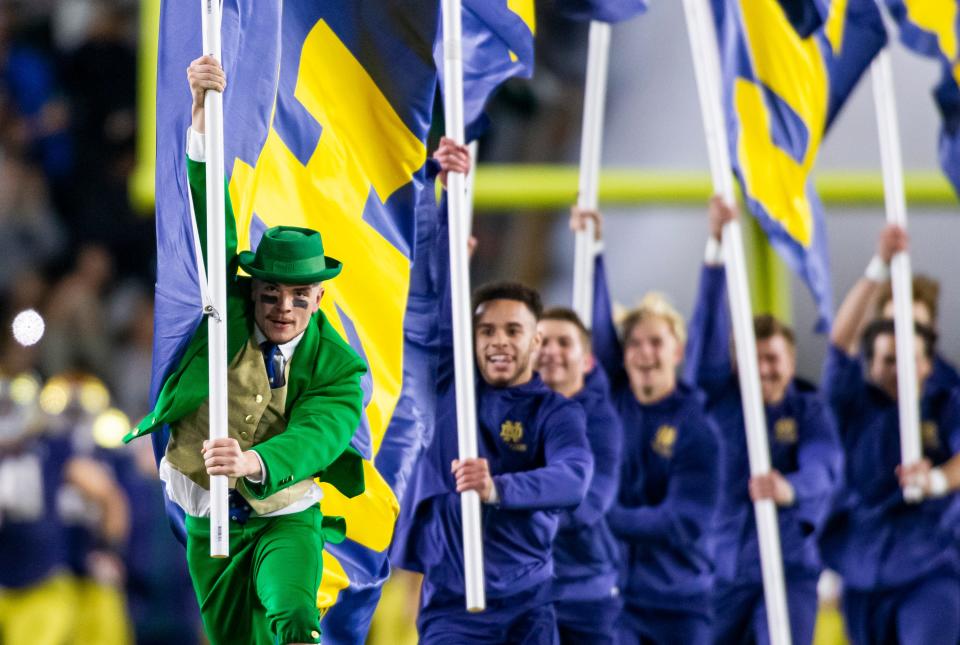 The Notre Dame Leprechaun mascot leads the cheerleaders and team on the field before the Notre Dame-USC NCAA college football game on Saturday, Oct. 23, 2021, at Notre Dame Stadium in South Bend. 