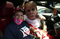Former senator Miriam Ramírez de Ferrer poses for the camera flanked by a Trump cardboard cutout moments before leaving for the headquarters of the Republican party in support of President Donald Trump's candidacy a few weeks before the presidential election next November, in Carolina, Puerto Rico, Sunday, Oct. 18, 2020. President Donald Trump and former Vice President Joe Biden are targeting Puerto Rico in a way never seen before to gather the attention of tens of thousands of potential voters in the battleground state of Florida. (AP Photo/Carlos Giusti)