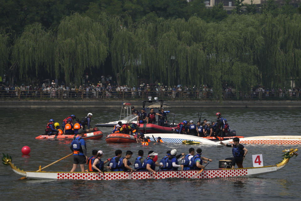 Rescuers help the dragon boat racers following a crash during the Dragon Boat festival at a canal in Tongzhou, on the outskirts of Beijing, Monday, June 10, 2024. The Duanwu festival, also known as the Dragon Boat festival, falls on the fifth day of the fifth month of the Chinese lunar calendar and is marked by celebrations like eating rice dumplings and racing dragon boats. (AP Photo/Andy Wong)