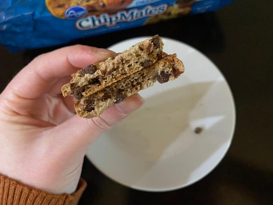 hand holding two pieces of kroger brand chocolate chip cookies