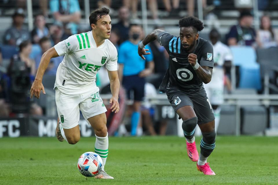 Jun 23, 2021; Saint Paul, MN, Saint Paul, MN, USA; Austin FC midfielder Jared Stroud (20) dribbles the ball against Minnesota United defender Romain Metanire (19) in the second half at Allianz Field.