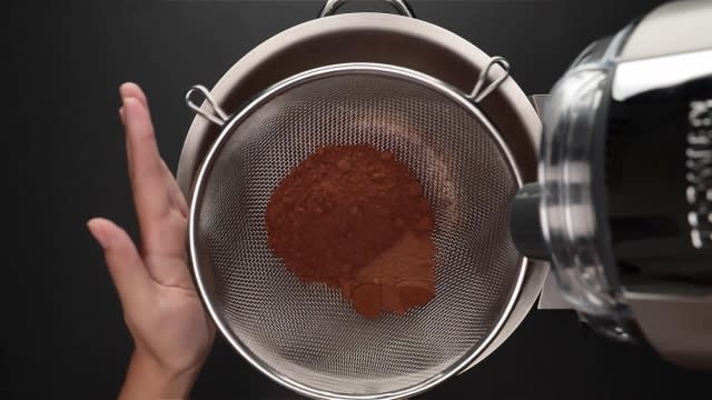 Sieving cocoa and milo powder into mixer