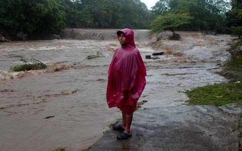 A resident stands on the shore of the Masachapa river, flooded by heavy rains by Tropical Storm Nate in the outskirts of Managua, Nicaragua - Credit: Reuters