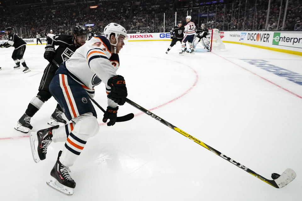 Edmonton Oilers center Connor McDavid, right, moves the puck while under pressure from Los Angeles Kings center Anze Kopitar during the third period in Game 4 of an NHL hockey Stanley Cup first-round playoff series Sunday, May 8, 2022, in Los Angeles. (AP Photo/Mark J. Terrill)