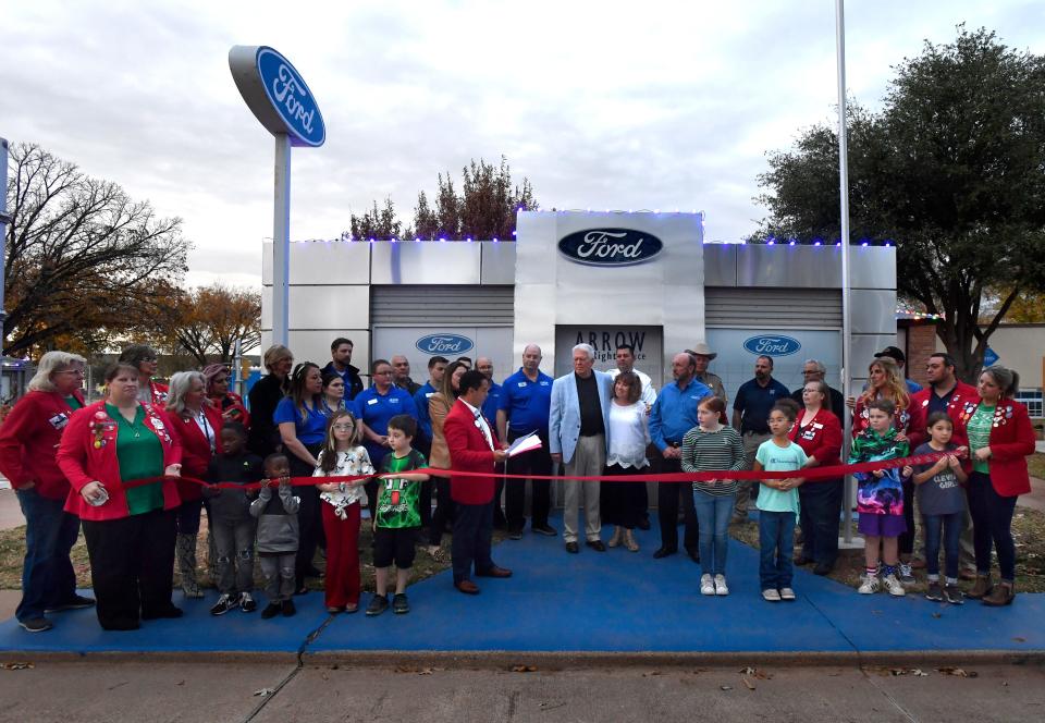Abilene Red Coats and others prepare to cut the ribbon on the latest addition to Safety City, a representation of Arrow Ford.