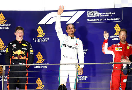 Formula One F1 - Singapore Grand Prix - Marina Bay Street Circuit, Singapore - September 16, 2018 Mercedes' Lewis Hamilton celebrates on the podium after winning the race alongside second placed Red Bull's Max Verstappen and third placed Ferrari's Sebastian Vettel REUTERS/Edgar Su