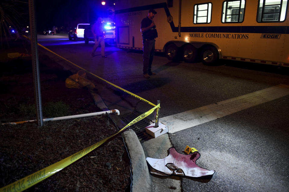 FILE - In this Oct. 3, 2018 file photo, blood-soaked evidence lies on Saxon Drive in the Vintage Place neighborhood where several members of law enforcement were shot, one fatally in Florence, S.C. State police investigated all but one officer-involved shooting in South Carolina in 2018. But the one they weren’t called out for was the most complex and deadliest encounter of all. A proposal in the state Senate would change that.(AP Photo/Sean Rayford. File)