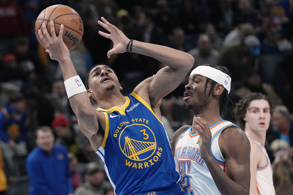 Warriors guard Jordan Poole (3) goes to the basket past Oklahoma City Thunder guard Shai Gilgeous-Alexander (2) in the first half of an NBA basketball game Monday, Jan. 30, 2023, in Oklahoma City. (AP Photo/Sue Ogrocki)