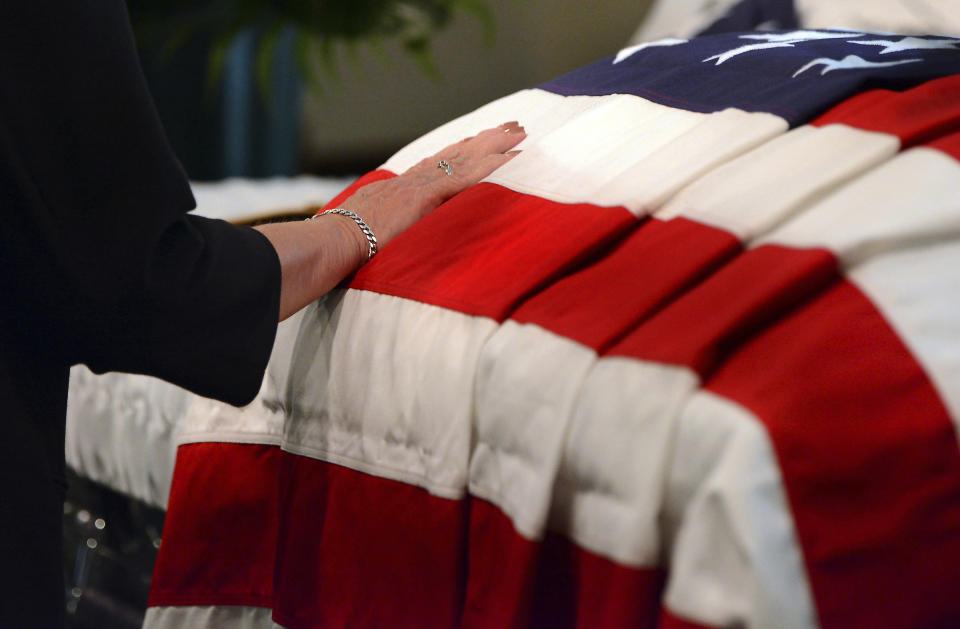 A woman touches the casket containing the remains of U.S. Army Pfc. paratrooper Willard "Bud" Jenkins of Scranton, Pa., who was killed in action in 1944 during World War II , on Wednesday, Sept. 27, 2018, at Edward J. Chomko Funeral Home in Scranton, Pa. ( Butch Comegys / The Scranton Times-Tribune via AP)