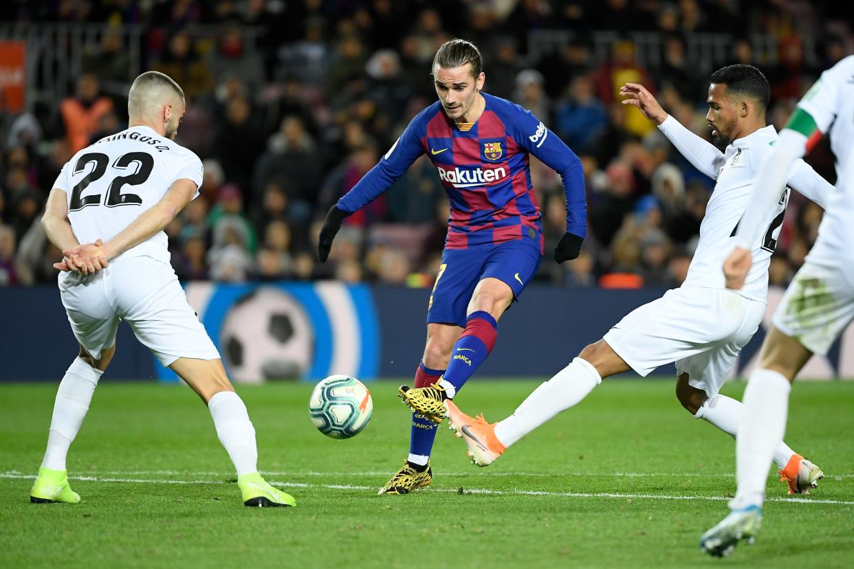 Barcelona's French forward Antoine Griezmann (C) vies with Granada's Portuguese defender Domingos Duarte (L) during the Spanish league football match between FC Barcelona and Granada FC at the Camp Nou stadium in Barcelona on January 19, 2020. (Photo by LLUIS GENE / AFP) (Photo by LLUIS GENE/AFP via Getty Images)