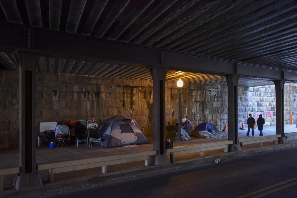 Pedestrians pass an expanding tent city under an overpass in Washington, D.C., last week. (Photo: The Washington Post via Getty Images)