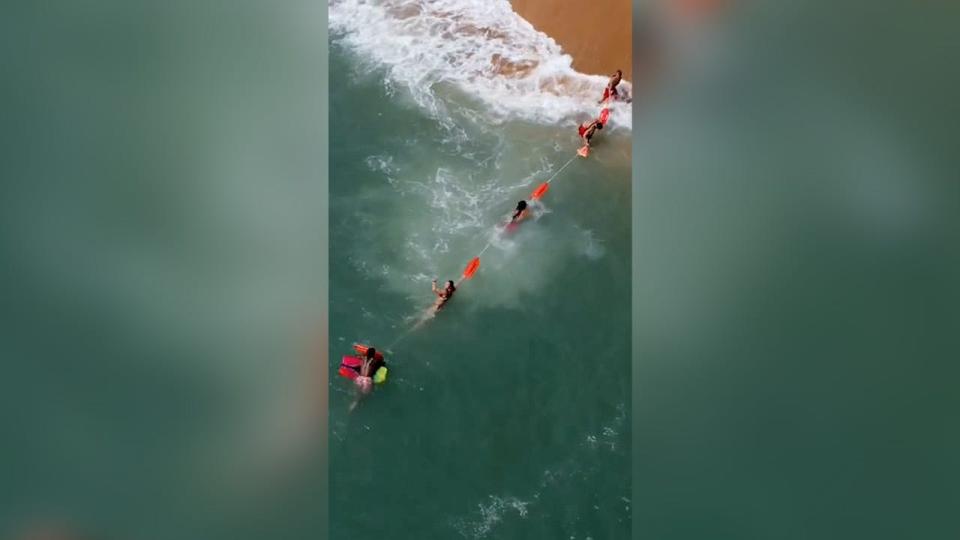 A local tattoo artist in Florida accidentally caught drone footage of a chain of lifeguards rescuing a stranded boogie boarder.