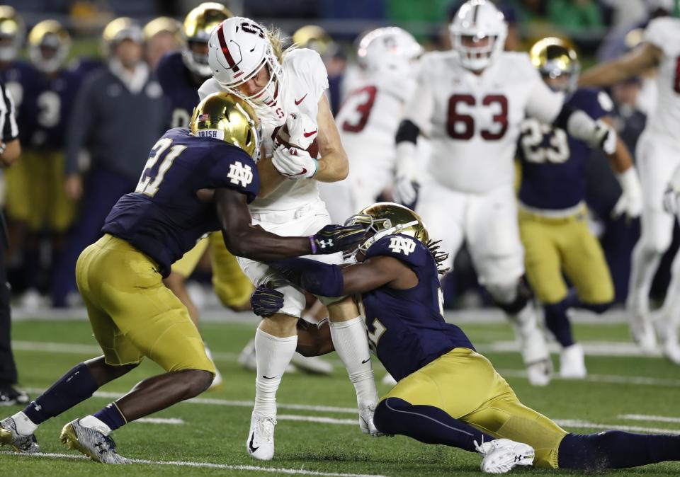 Stanford wide receiver Trenton Irwin is stopped by Notre Dame safety Jalen Elliott (21) and linebacker Asmar Bilal during the first half of an NCAA college football game Saturday, Sept. 29, 2018, in South Bend, Ind. (AP Photo/Carlos Osorio)