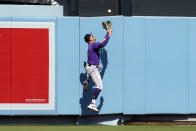 Colorado Rockies center fielder Yonathan Daza leaps at the wall to catch a fly ball by Los Angeles Dodgers' Cody Bellinger during the third inning of a baseball game Sunday, Oct. 2, 2022, in Los Angeles. Bellinger drove in a run with a sacrifice on the play. (AP Photo/Marcio Jose Sanchez)