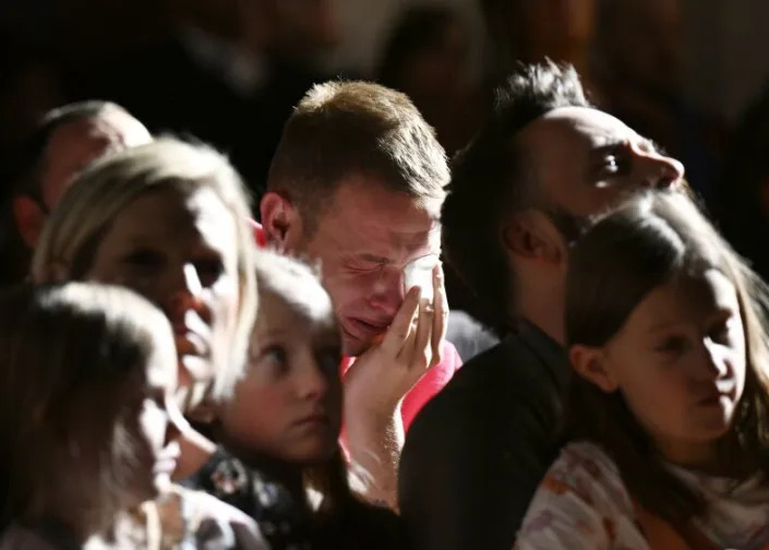 R.J. Lewis, center, attends a vigil at All Souls Unitarian Church with others, Sunday, Nov. 20, 2022, in Colorado Springs, Colo., following a fatal shooting at gay nightclub Club Q late the night before. Lewis was at Club Q when a 22-year-old gunman entered the LGBTQ nightclub killing several people and injuring multiple others. (RJ Sangosti/The Denver Post via AP)