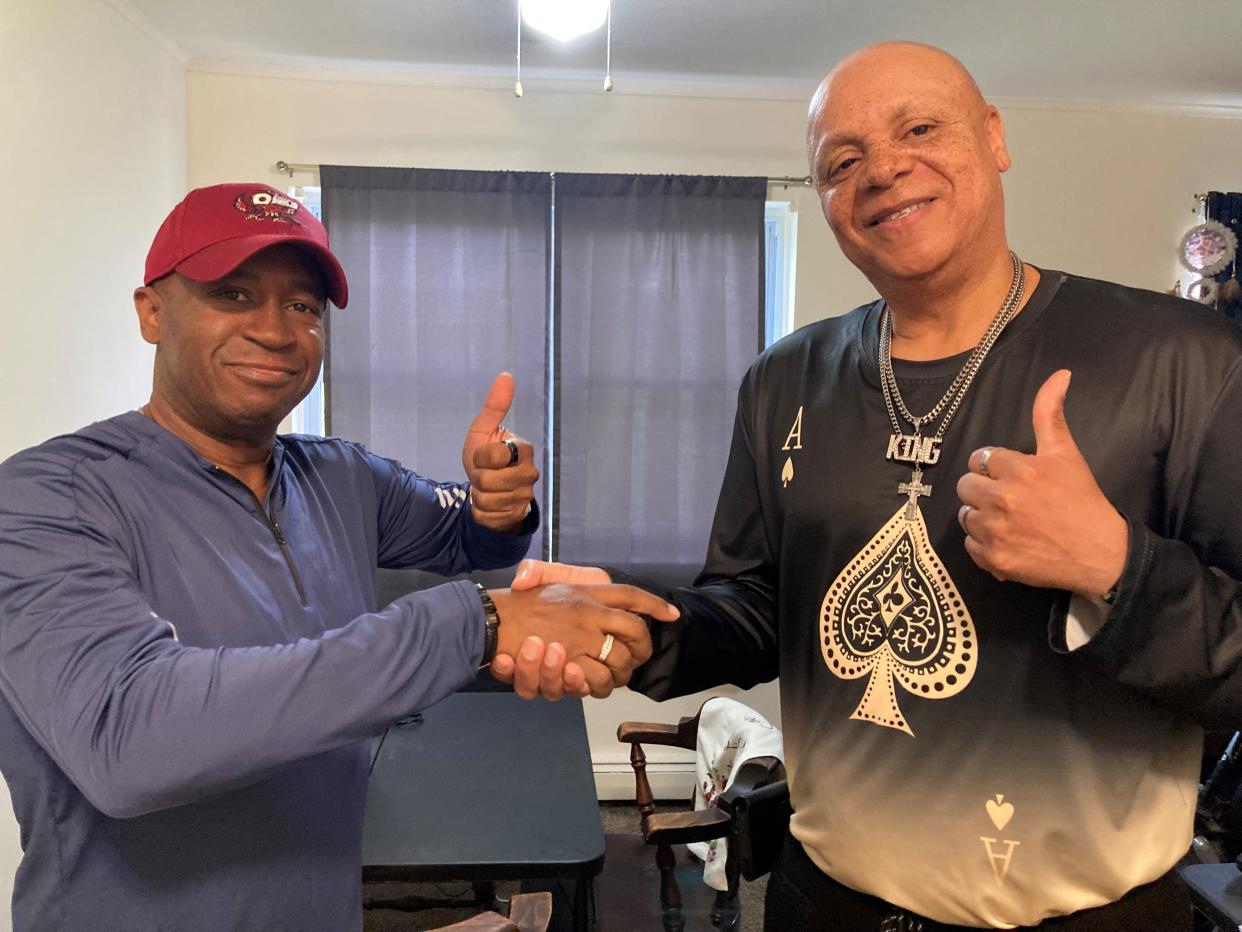 Darryl Watkins (left) displays his wedding band as he shakes hands with 33 East Car Wash employee Willie Evans (right), who recovered the band from the trash at the Howell car wash.