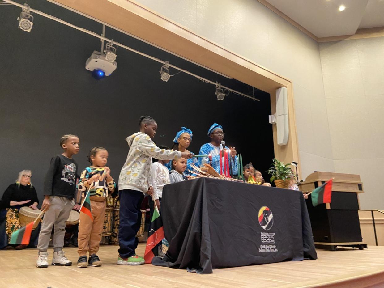 Reis Penn-Davis, a 9-year-old South Bend resident, lights a candle during the Kwanzaa celebration on Thursday at the St. Joseph County Public Library. The event was hosted by the Indiana Black Expo’s South Bend chapter.