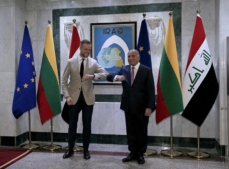 Iraqi Foreign Minister Fouad Hussein, right, elbow bumps with visiting Lithuanian Foreign Minister Gabrielius Landsbergis, in Baghdad, Iraq, Thursday, July 15, 2021. (AP Photo/Khalid Mohammed)